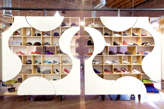 Sistema espositivo personalizzabile in legno e pannelli bianchi nella sneaker boutique di Los Angeles