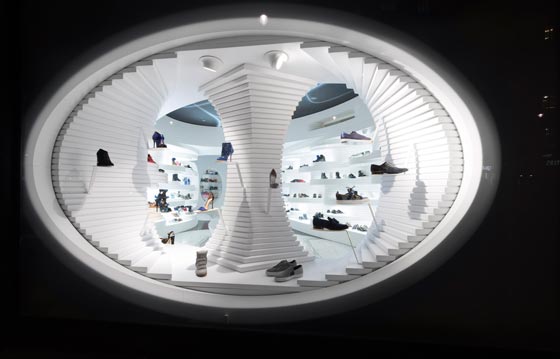 Visuale notturna della vetrina ellittica del flagship store Shoebaloo ad Amsterdam.