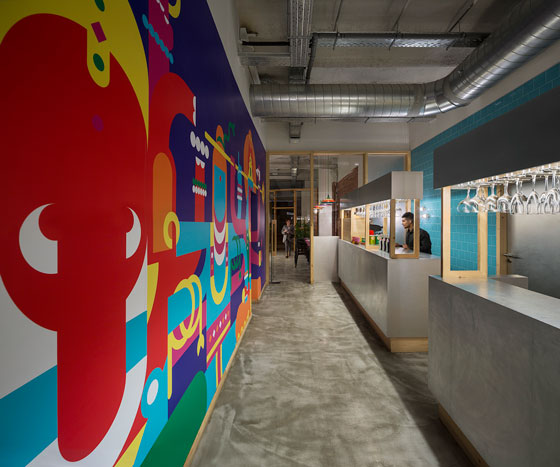 TANDOOR-restaurant-barcelona-by-isabel-lopez-vilalta Colorful mural by Outro Studio along corridor at Tandoor Restaurant Barcelona, with visible industrial ceiling and turquoise tiles