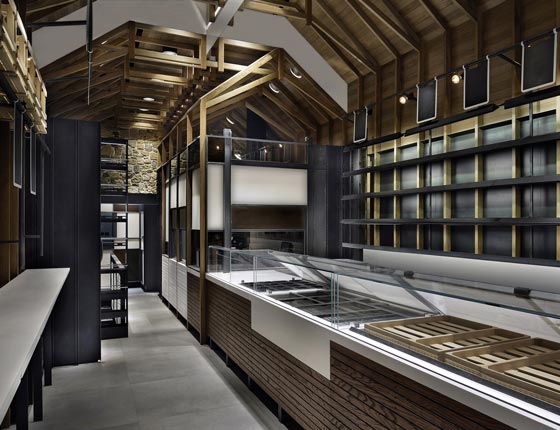 Interno Klea Fine Bakery con travature in rovere e acciaio nero.