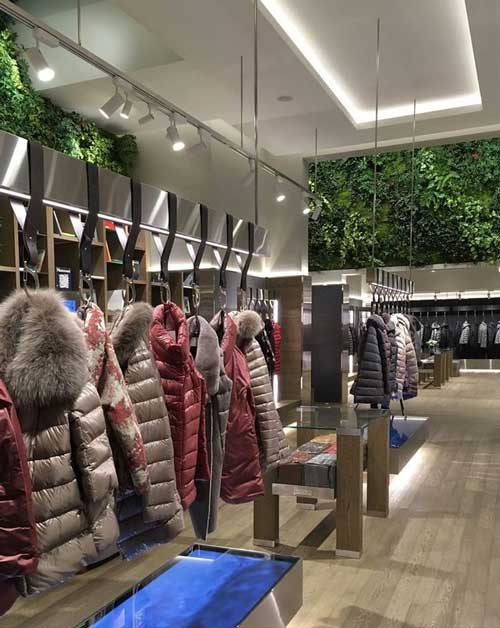Vista interna del flagship store Herno a Seoul con esposizione di piumini e arredi in legno