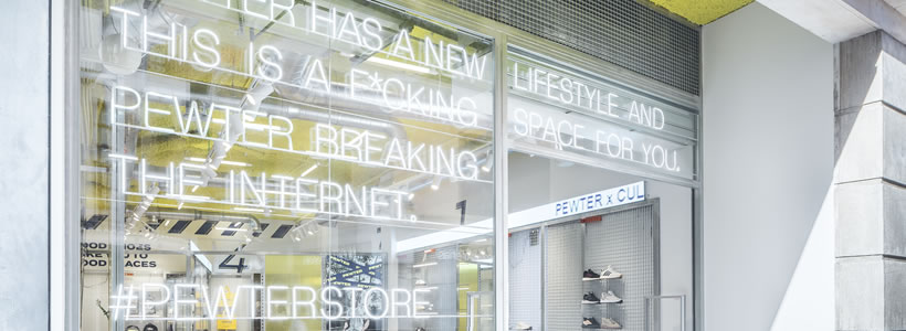 Flagship store Pewter con espositori metallici e soffitto giallo