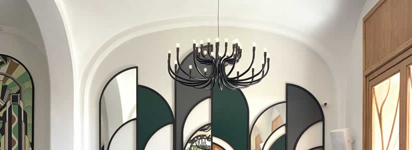 Chandelier in metallo nero “Snoob” e sospensioni “Nox” in vetro ambrato di Karman per illuminare La Biglietteria.