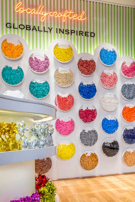 Interno di Balloon Kraft Store con banco curvo su misura, espositori per nastri e parete di palloncini colorati