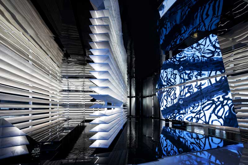 Landscape-inspired retail interior with dark materials and reflective surfaces