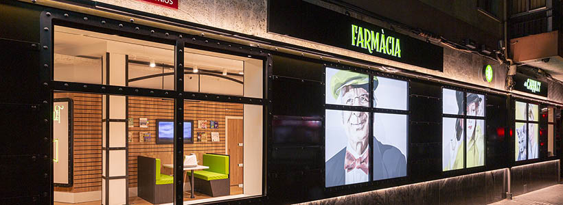 Facciata farmacia ispirata a un treno con pannelli retroilluminati