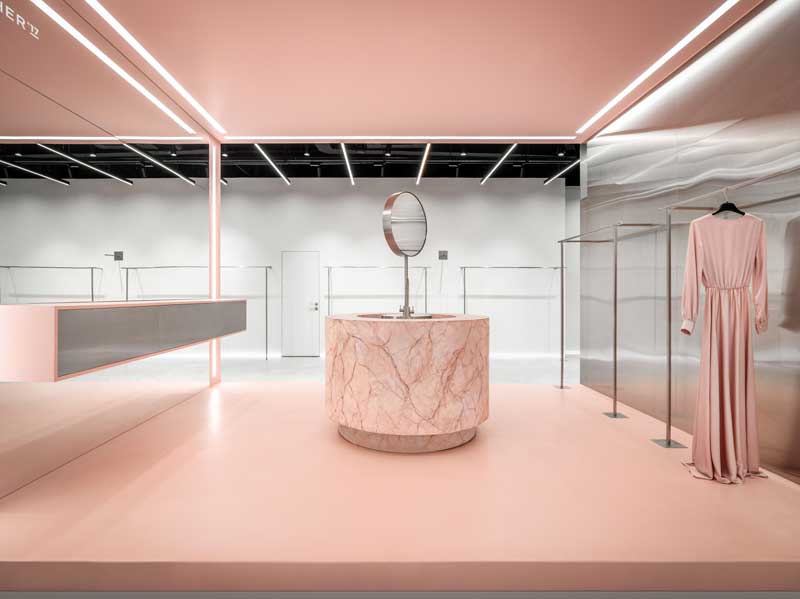 Area rosa showroom Cher’17 con podio in marmo e appendiabiti in acciaio