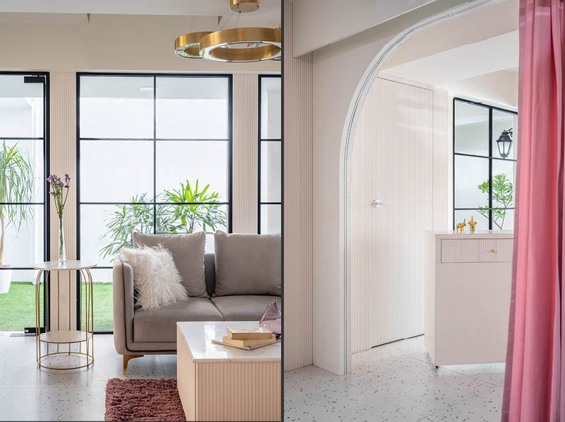 Interno boutique Raslila con arco centrale, tende cipria e display moda