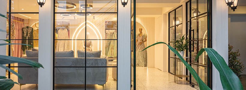 4. Vista esterna boutique Raslila con facciata in vetro e illuminazione calda