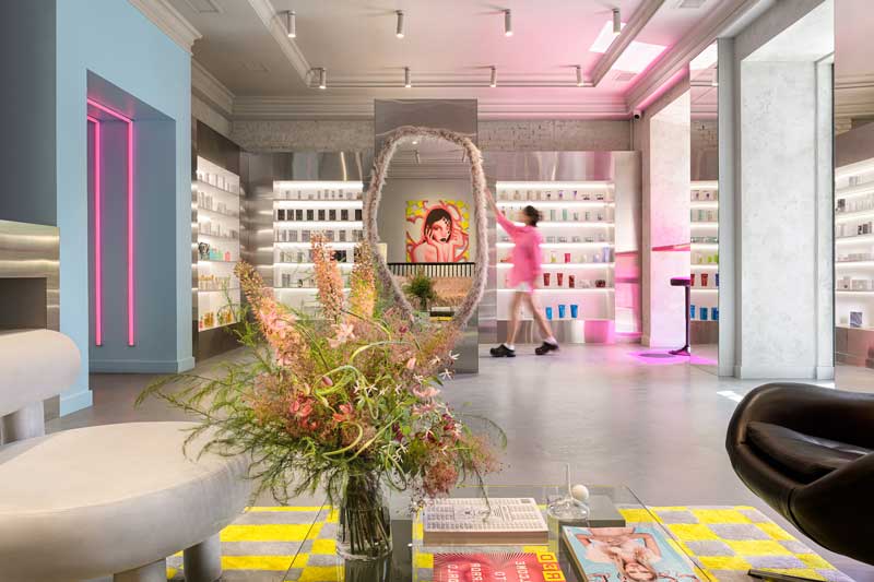 Interni del negozio Mila’s Beauty con scaffalature metalliche, illuminazione RGB e concept industriale