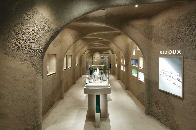 Vista interna della gioielleria Bizoux progettata da Studio Gavel con pareti materiche, nicchie espositive illuminate e concept ispirato alle grotte naturali