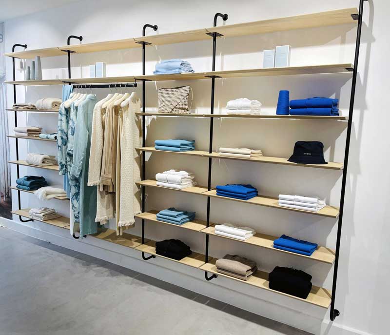 • allestimento raffinato per la boutiwue Malo Cashmere a Marbella con scaffali in legno chiaro e dettagli minimal, dove predominano tonalità neutre e azzurre, evocando il mood rilassato della Costa del Sol.