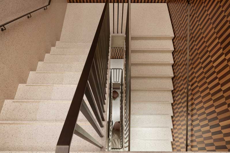 Terrazzo staircase in the Rolex boutique in Milan with walnut boiserie and vertical spatial design