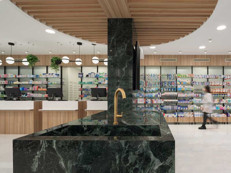 Spazio interno farmacia con percorsi lineari e organizzazione funzionale