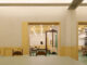 Interior dining room with pastel yellow walls, framed doorway and geometric ceiling lights inside Bitter Sweetie dessert shop in Tianjin