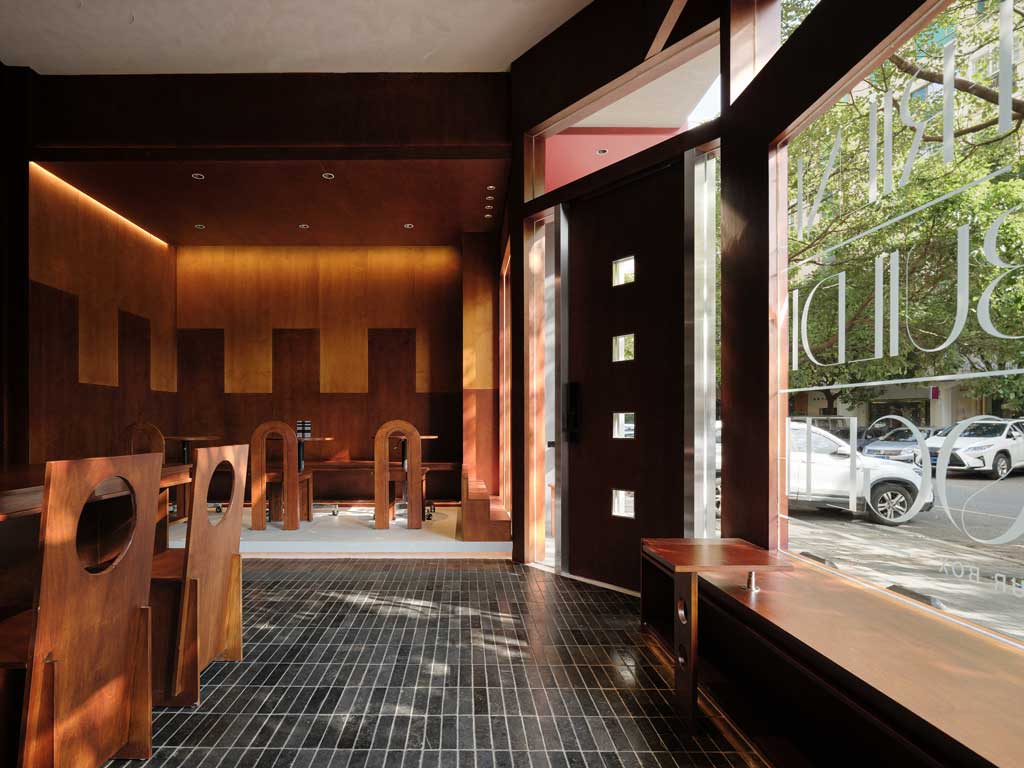 Low wooden bench are arranged along the glass wall