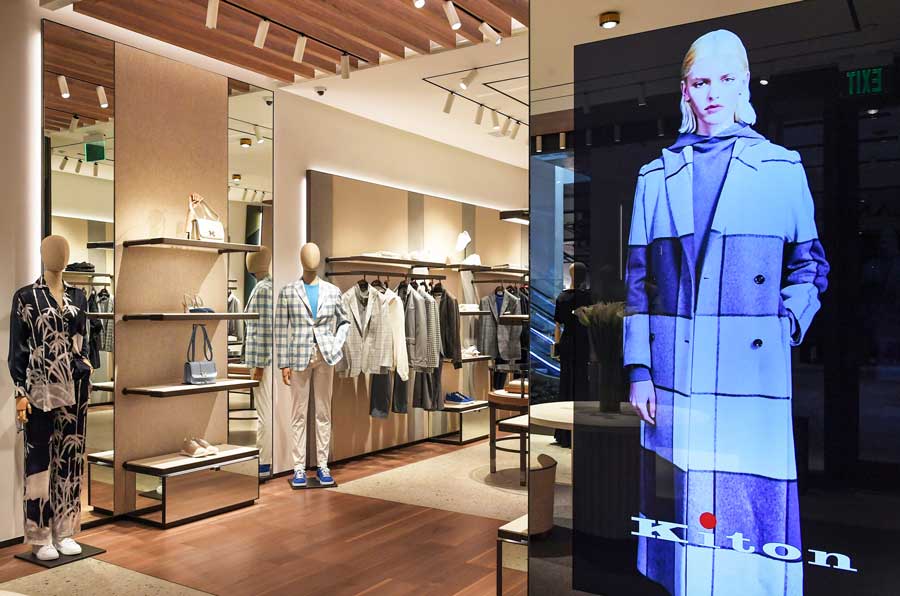 Retail display area with custom furniture and linear layout in Kiton store