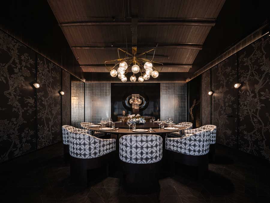 Private dining room with floral wallpaper, mirrors and integrated lighting