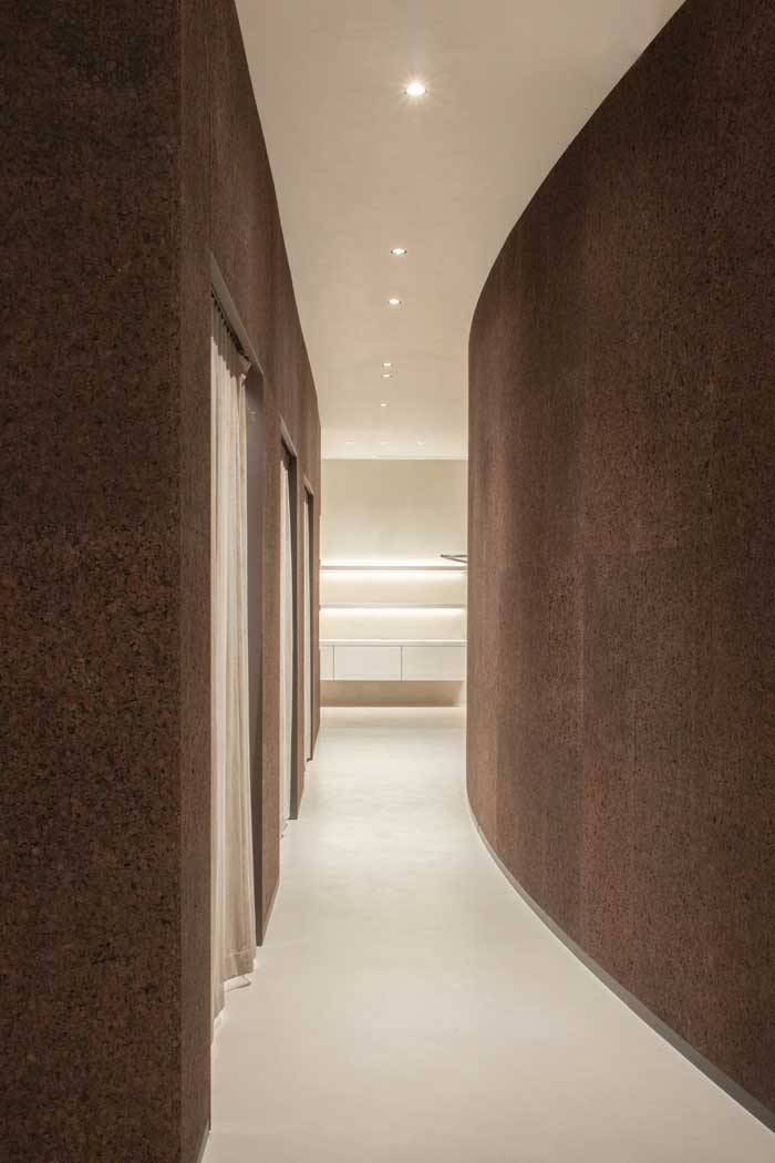 Curved partition wall clad in raw black cork