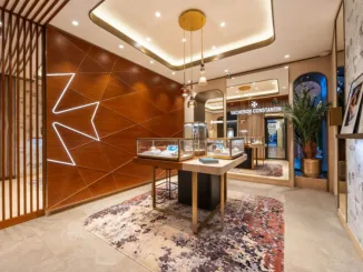 Interno della boutique Vacheron Constantin a Roma, con espositori illuminati, parete decorata con Croce di Malta retroilluminata e dettagli di design raffinato.