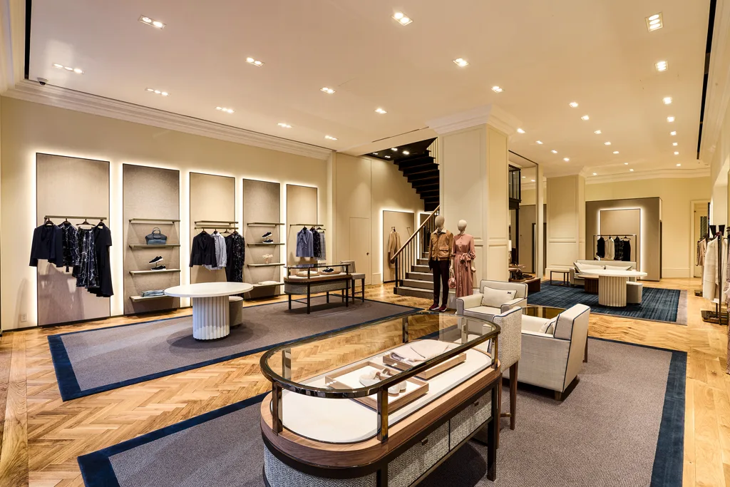 Interni del flagship store Kiton a Ginza, Tokyo: design elegante con espositori minimalisti, arredi personalizzati e dettagli di lusso. L'ambiente accogliente esprime al meglio il concetto di quiet luxury.