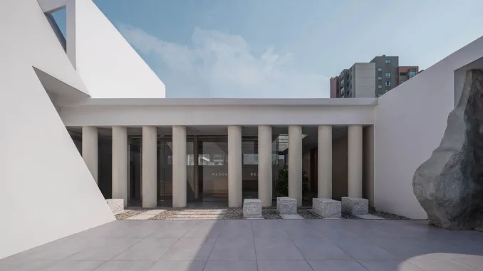 Facciata moderna di un concept store con colonne minimaliste, dettagli geometrici e un design essenziale che combina elementi architettonici contemporanei e tradizionali