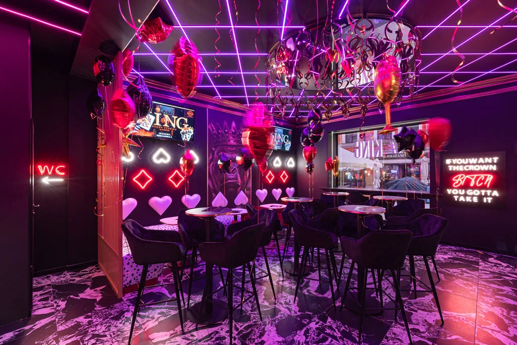 The #King Cocktail Bar in Poznań is an exclusive venue that blends regal design and modernity, featuring dynamic LED lighting, artistic murals, and luxurious details.