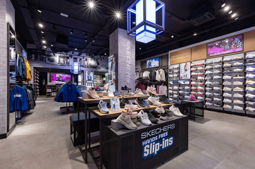 Interno del negozio Skechers in Corso Buenos Aires, Milano. L'esposizione presenta un'ampia selezione di scarpe, abbigliamento e accessori