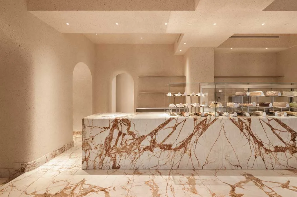 Pastry shop counter with marble finishes and brass details