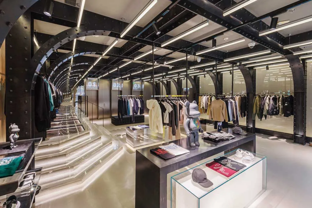 Interior of Roarguns' futuristic concept store in Beijing, featuring a black metal structure, LED lighting and minimalist displays, and fitting rooms designed to resemble elevators
