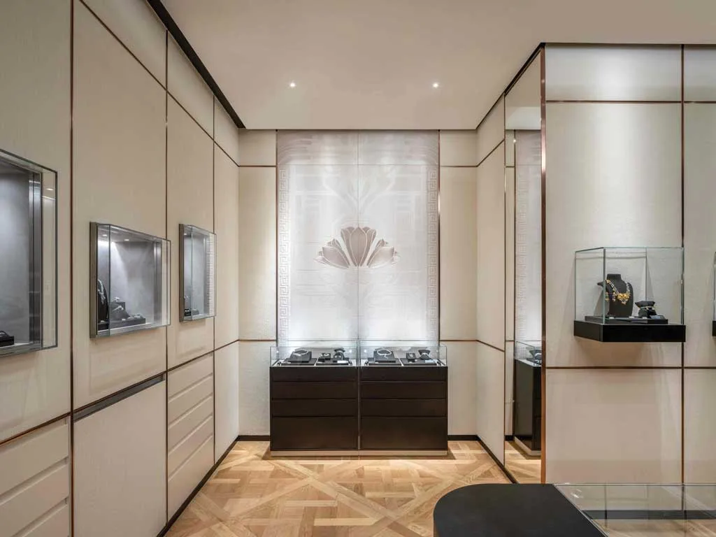 Dettaglio degli espositori gioielli nel flagship store Giovanni Raspini a Shanghai con pareti chiare, motivi Art Déco e vetrine retroilluminate