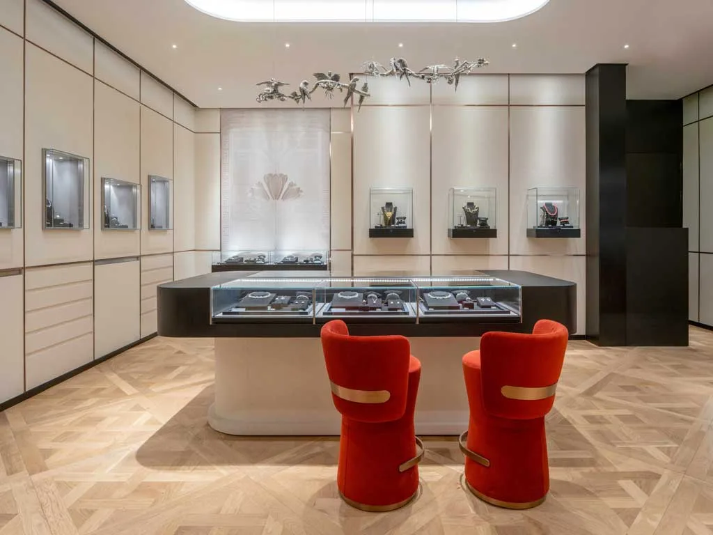 Interno del flagship store Giovanni Raspini a Shanghai con espositori gioielli, tavolo centrale e sedute in velluto rosso, design Vudafieri-Saverino Partners