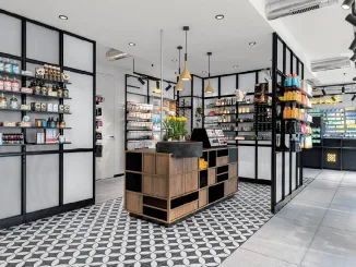 Interni moderni di una farmacia progettata con il metodo A / M LAB, caratterizzata da scaffalature eleganti, illuminazione calda e un layout studiato per migliorare la customer experience.