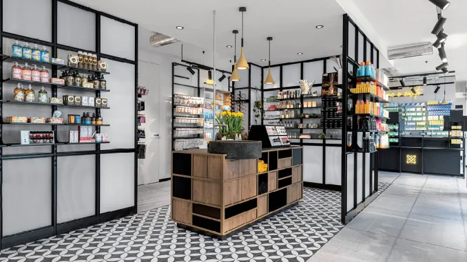 Interni moderni di una farmacia progettata con il metodo A / M LAB, caratterizzata da scaffalature eleganti, illuminazione calda e un layout studiato per migliorare la customer experience.