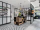 Interni moderni di una farmacia progettata con il metodo A / M LAB, caratterizzata da scaffalature eleganti, illuminazione calda e un layout studiato per migliorare la customer experience.