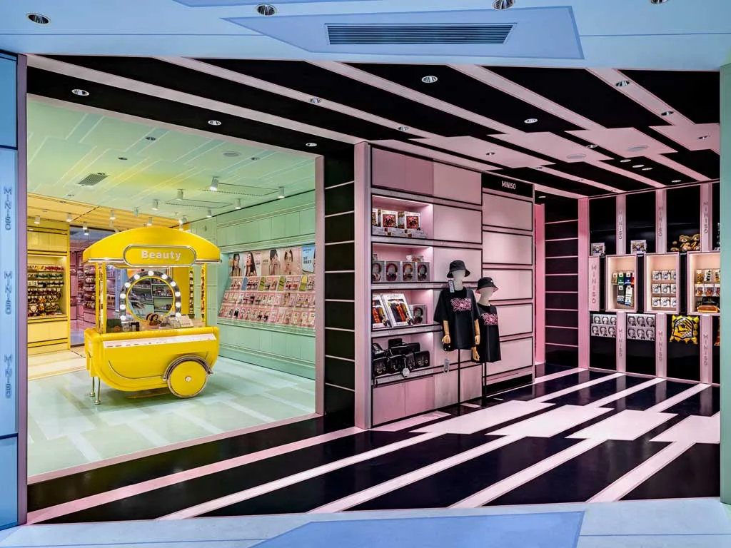 Area Multifunzione di Miniso Land Shanghai con espositori dedicati a beauty, moda e cultura pop, caratterizzata da un design ispirato al montaggio cinematografico e da una scenografia che guida il percorso dei visitatori.