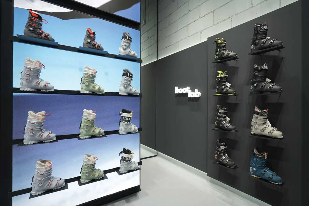 Display of ski boots in the Boot Lab area of the Rossignol flagship store in Shanghai with backlit walls and technical layout.