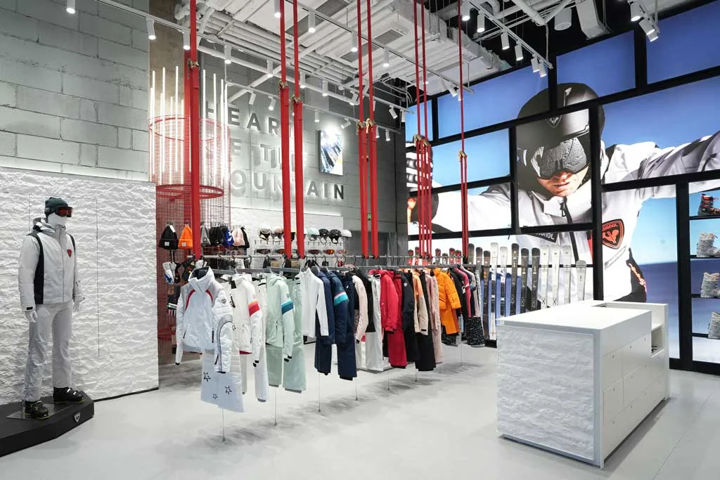 Interior of the Rossignol flagship store in Shanghai featuring technical ski apparel, red vertical installations, and immersive wall graphics
