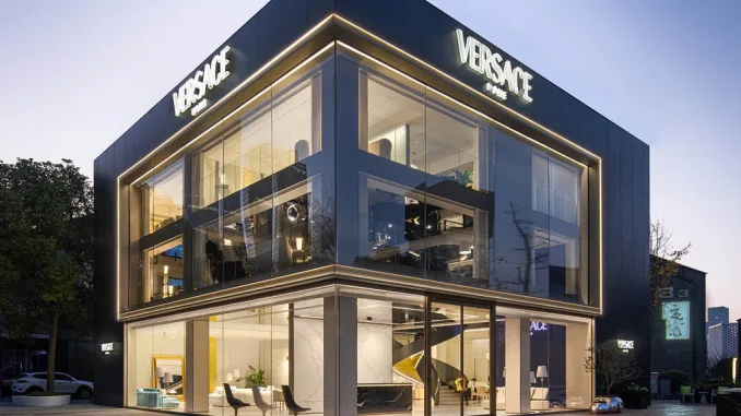 Facciata esterna del flagship store Versace Home a Qianjiang Century City, Hangzhou. L'edificio moderno, con ampie vetrate e illuminazione a LED, riflette l'estetica di lusso del brand.