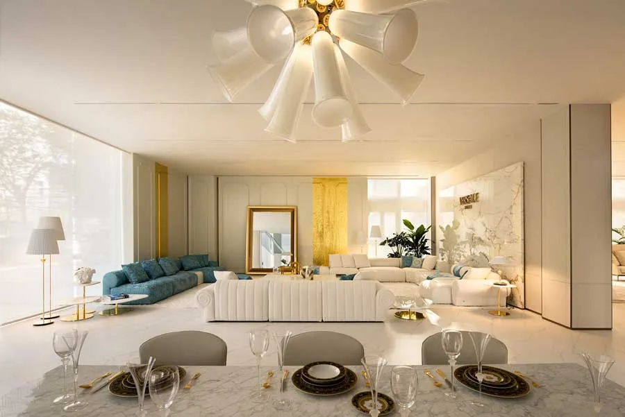 Elegant living area in the Versace Home flagship store in Qianjiang Century City, Hangzhou. A refined mix of white and blue sofas, gold accents, and marble walls, illuminated by a striking designer chandelier.
