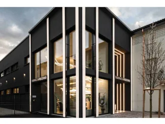 Facciata contemporanea della Farmacia Fecchio con ampie vetrate, illuminazione verticale integrata e rivestimento scuro, progetto di AMlab, foto di Guglielmo Verrienti