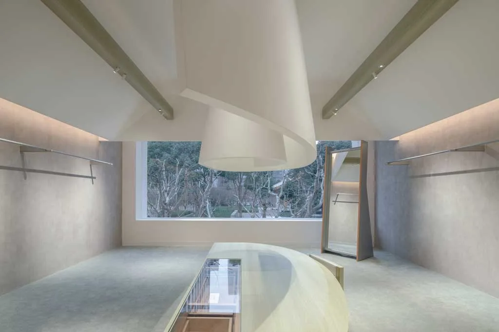 Upper area of the AVVENN concept store in Shanghai with a panoramic window, curved wooden display counter and sculptural suspended element
