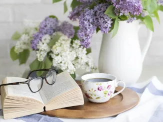 Decorazione primaverile per la casa con fiori freschi, libro e tazza da tè: un’idea per creare atmosfera accogliente e rilassante in salotto o cucina