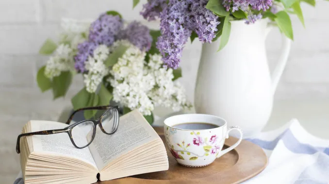 Decorazione primaverile per la casa con fiori freschi, libro e tazza da tè: un’idea per creare atmosfera accogliente e rilassante in salotto o cucina