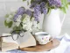 Decorazione primaverile per la casa con fiori freschi, libro e tazza da tè: un’idea per creare atmosfera accogliente e rilassante in salotto o cucina