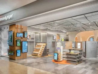 Ingresso del concept store moodytiger con soffitto ondulato, display multimediali e layout modulare, progettato da Sò Studio per il retail dedicato ai bambini