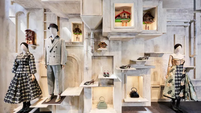Allestimento scenografico della boutique temporanea Ephemeral di Antonio Marras in Via Montenapoleone a Milano, con manichini, accessori e orologi a cucù in un'esposizione artistica durante la Milan Design Week 2025.