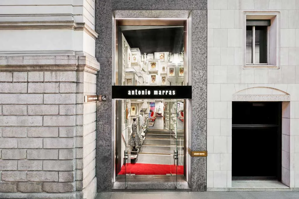 Ingresso della boutique temporanea Ephemeral di Antonio Marras in Via Montenapoleone a Milano, con vetrina scenografica e tappeto rosso durante la Milan Design Week 2025.