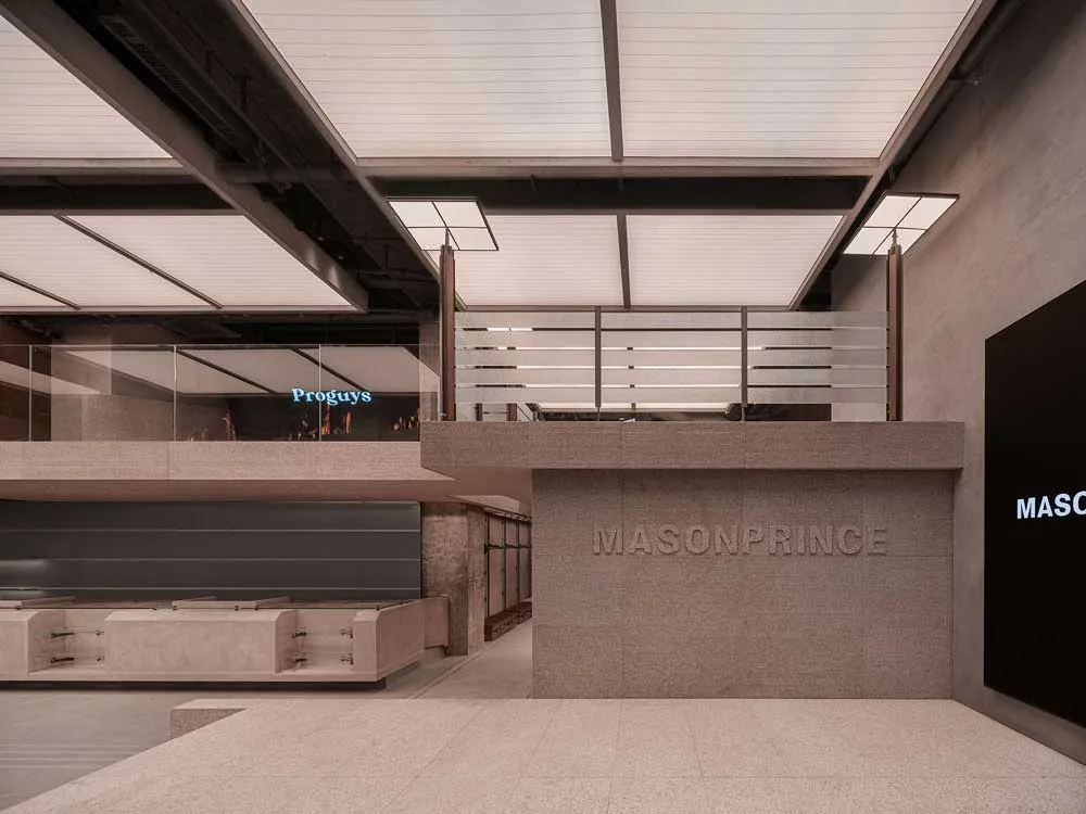 Parete-logo in granito e ingresso principale del flagship MASONPRINCE