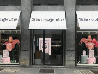 Vetrina del flagship store Samsonite con allestimento dedicato alla collezione Frida Kahlo x Samsonite durante la Design Week, con elementi floreali, valigie illustrate e ritratti artistici